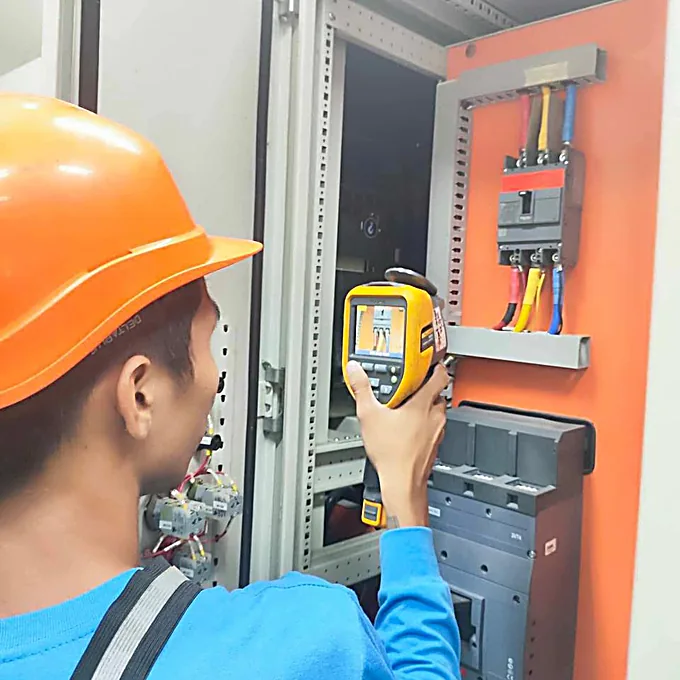 Bestcor technician performing thermal inspection of an electrical panel.